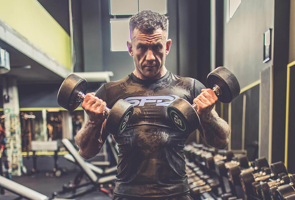 Padesátiletý muž trénuje v posilovně