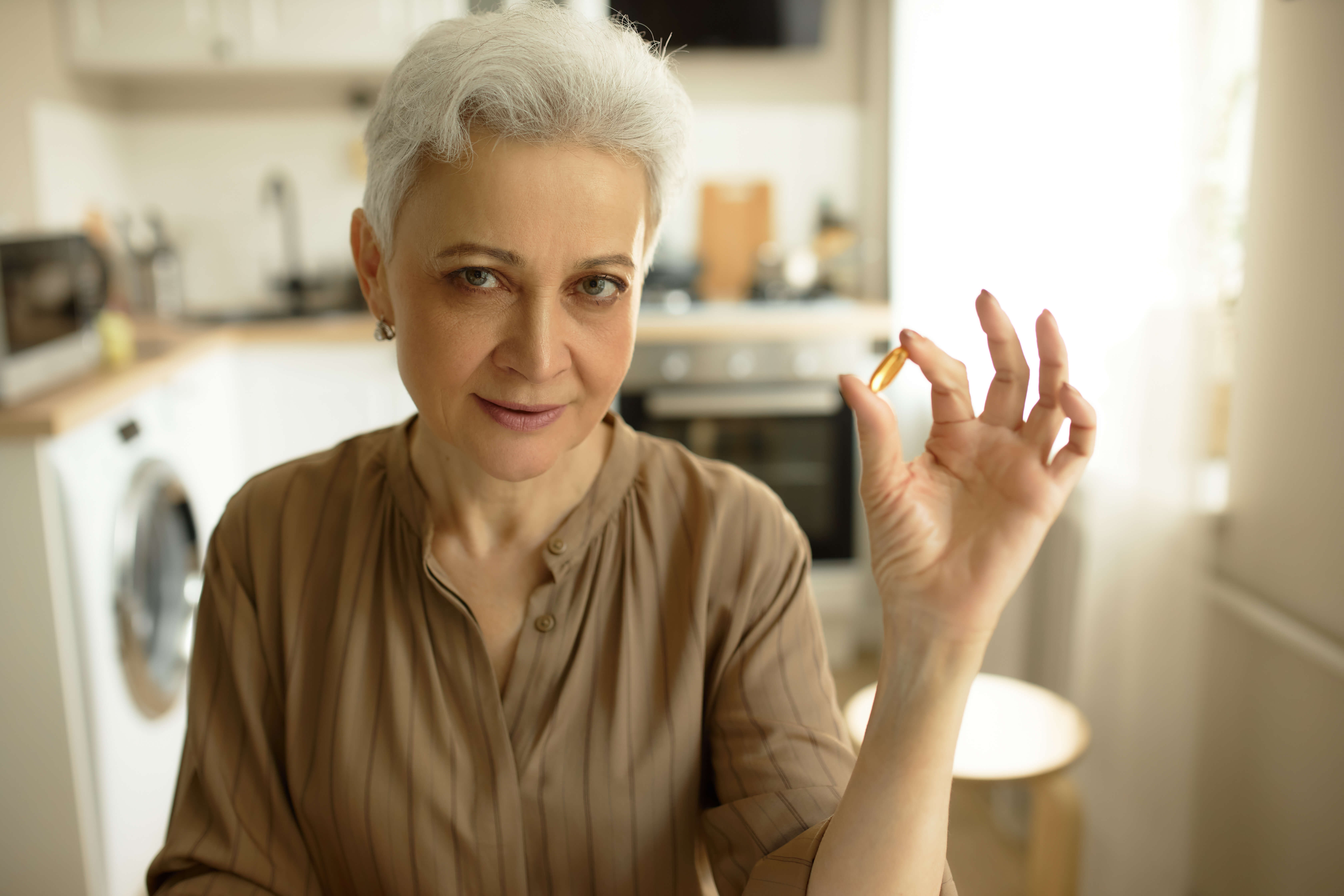 starší žena s kapsli omega 3