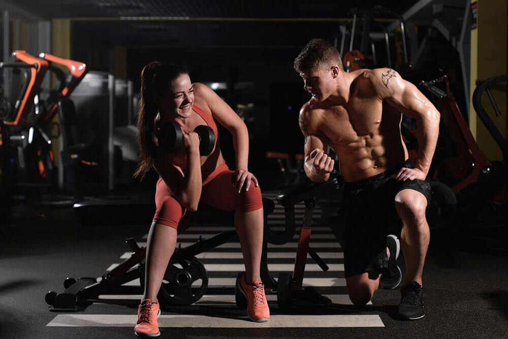 pár cvičící v posilovně