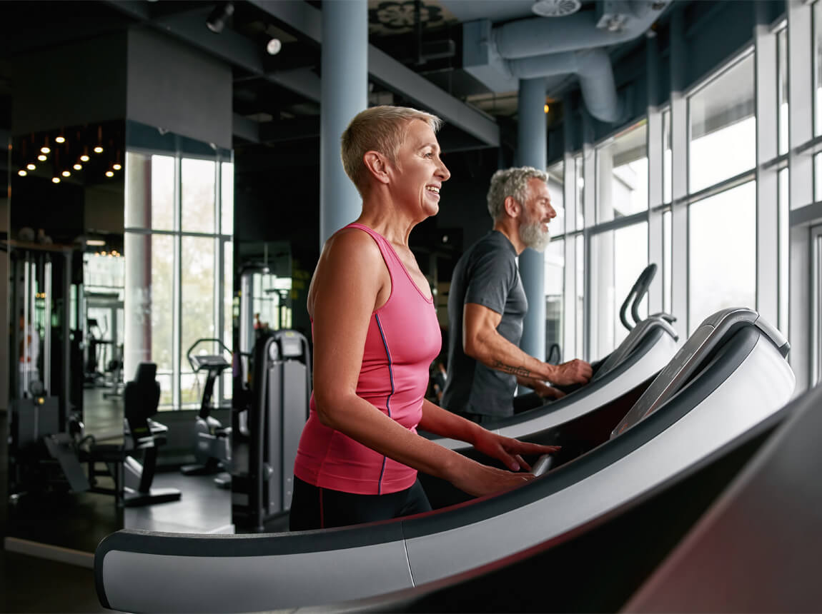 starší žena - běžecký pás, posilovna 